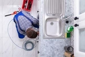 a plumber snaking a drain